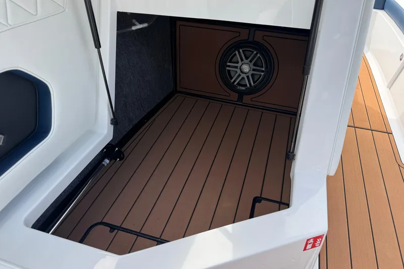 Slide: The Image of 2026 Nautique Super Air Nautique GS22 storage compartment with speaker and teak flooring. - 24