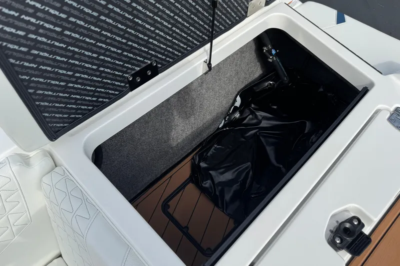 Slide: The Image of 2026 Nautique Super Air Nautique GS22 storage compartment with open lid and interior view. - 25
