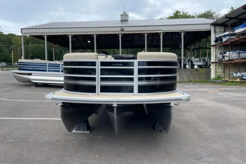 Slide: The Image of 2026 Harris Cruiser 230 pontoon boat parked in a marina lot. - 2