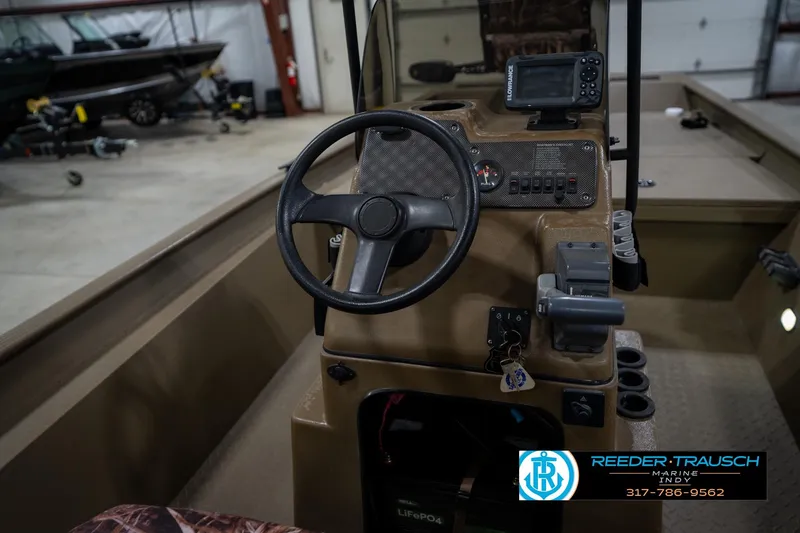 Slide: The Image of 2007 G3 1860 CCT boat dashboard with steering wheel and control panel in a garage. - 28