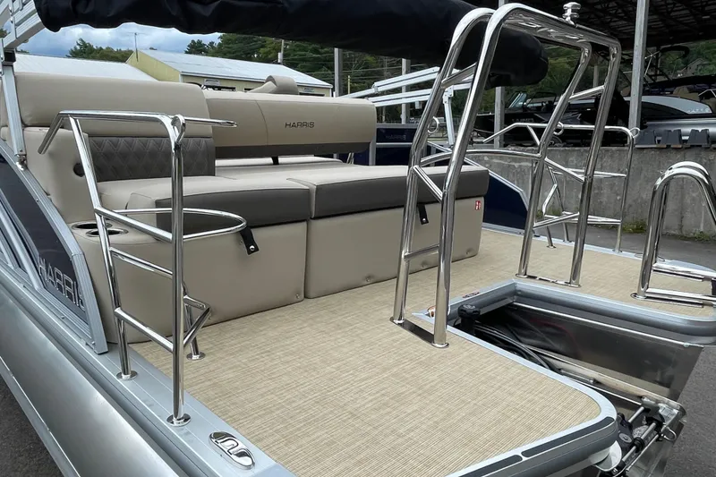 Slide: The Image of 2026 Harris Cruiser 230 pontoon boat with beige seating and stainless steel railings. - 5