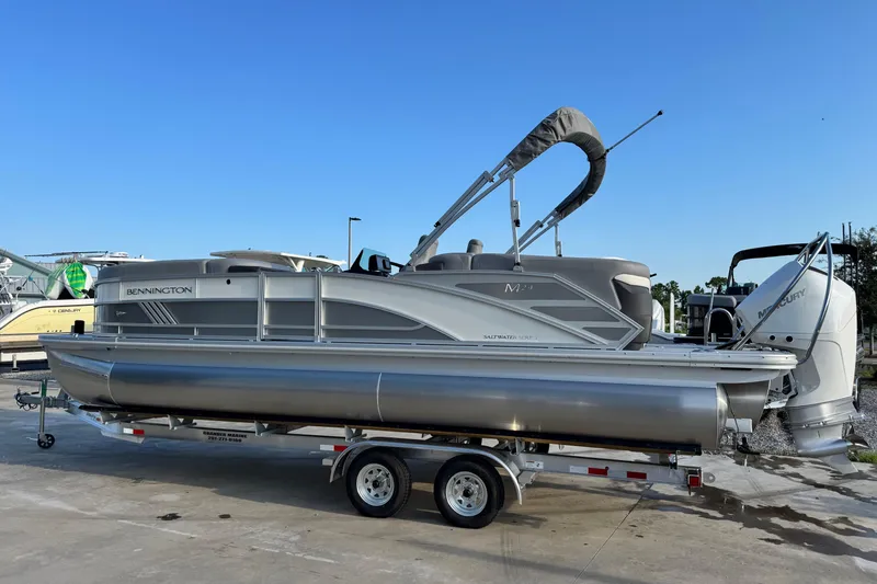 Slide: The Image of 2026 Bennington 24 MFB pontoon boat on trailer, clear sky background. - 3