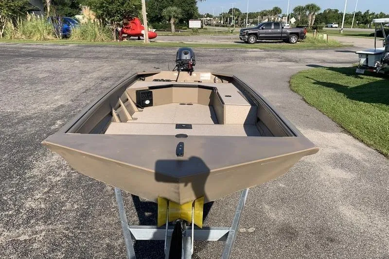 Slide: The Image of 2025 SeaArk DXS 1548 DKLD boat on trailer, parked outdoors. - 6