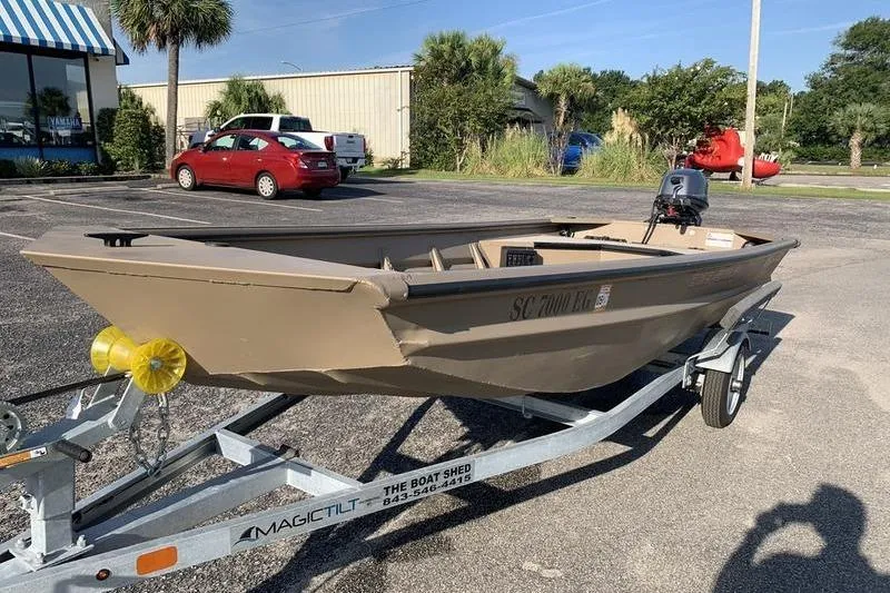 Slide: The Image of 2025 SeaArk DXS 1548 DKLD boat on trailer in parking lot, sunny day. - 7