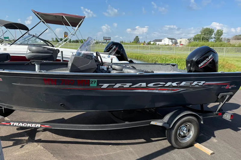 Slide: The Image of 2022 Tracker PGV16SC fishing boat with Mercury engine on trailer, parked outdoors. - 4