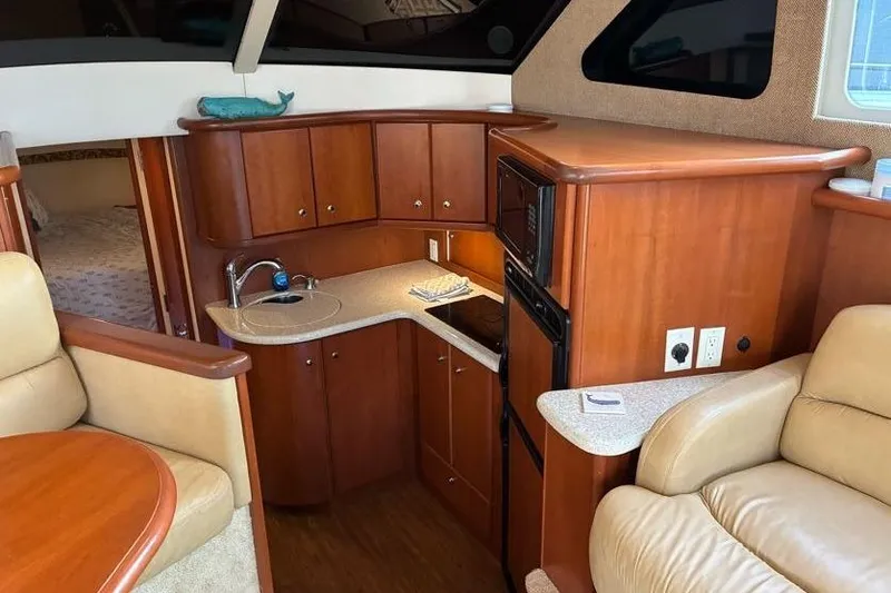 Slide: The Image of Interior of 2005 Silverton 34 Convertible yacht with compact kitchen and seating area. - 15