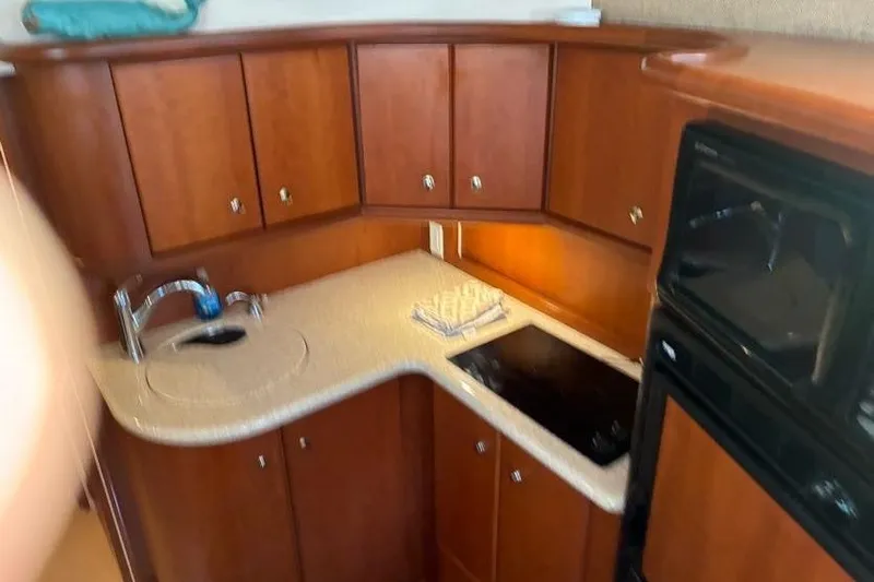 Slide: The Image of 2005 Silverton 34 Convertible yacht kitchen with wooden cabinets and modern appliances. - 18