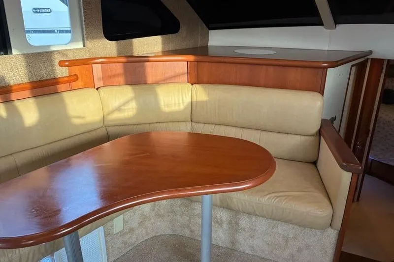 Slide: The Image of Interior of 2005 Silverton 34 Convertible yacht with beige seating and wooden table. - 20