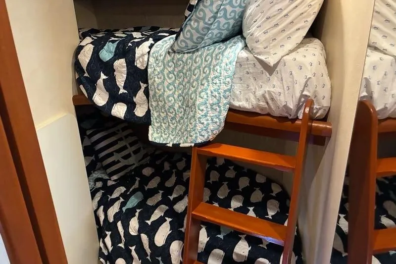 Slide: The Image of Bunk beds with nautical-themed bedding in a 2005 Silverton 34 Convertible boat cabin. - 22