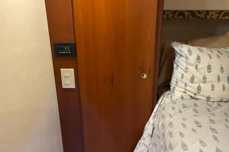 Slide: The Image of Interior of 2005 Silverton 34 Convertible with wooden door and patterned bedding. - 26