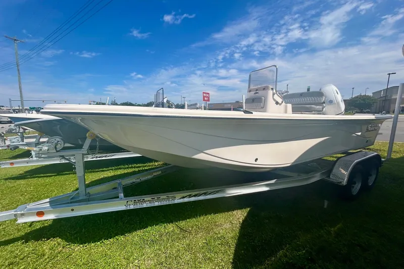 The Image of 2025 Carolina Skiff 21 LS boat on trailer under clear blue sky. - 0