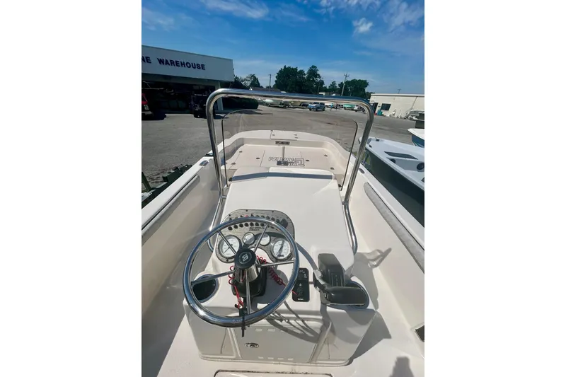 Slide: The Image of 2025 Carolina Skiff 21 LS boat console with steering wheel and controls, parked outdoors. - 7