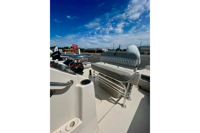 Slide: The Image of 2025 Carolina Skiff 21 LS boat interior with seating and steering wheel under a clear blue sky. - 9