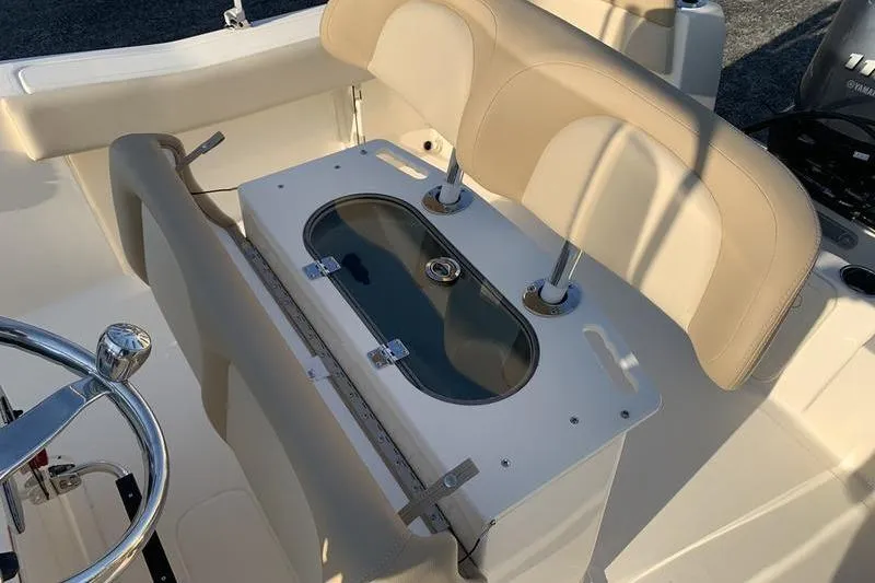 Slide: The Image of 2026 Scout 195 Sportfish boat interior with beige seating and steering wheel. - 11