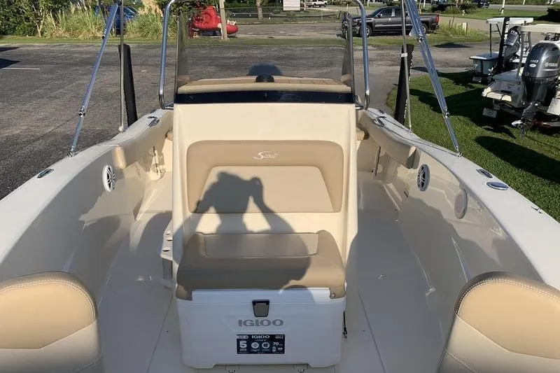 Slide: The Image of 2026 Scout 195 Sportfish boat interior with beige seating and Igloo cooler. - 22