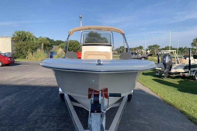 Slide: The Image of 2026 Scout 195 Sportfish boat on trailer, parked outdoors under clear sky. - 6