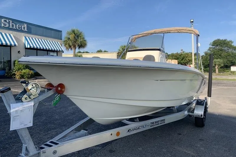 Slide: The Image of 2026 Scout 195 Sportfish boat on trailer outside dealership. - 7