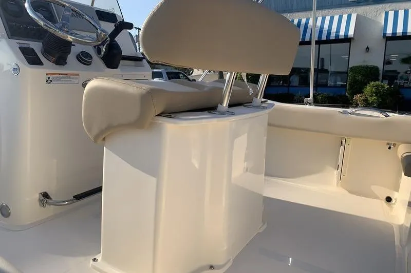 Slide: The Image of 2026 Scout 195 Sportfish boat interior with beige seating and steering console. - 9