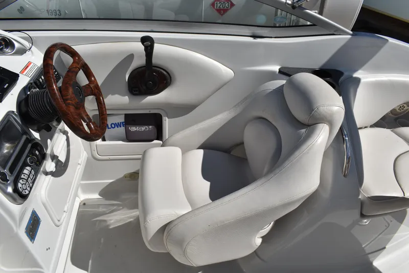 Slide: The Image of 2005 Crownline 275 CCR boat cockpit with white seating and wooden steering wheel. - 14