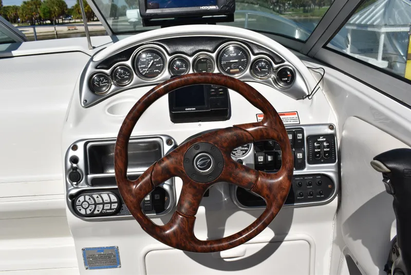 Slide: The Image of 2005 Crownline 275 CCR boat dashboard with wood-grain steering wheel and instrument panel. - 17