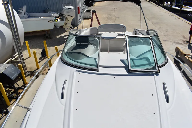 Slide: The Image of 2005 Crownline 275 CCR boat with open deck and windshield, docked at marina. - 24