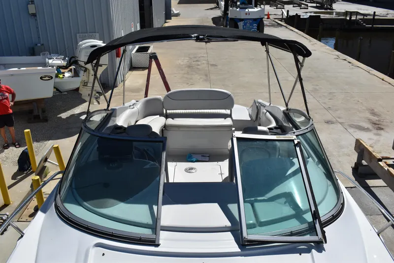 Slide: The Image of 2005 Crownline 275 CCR boat with open windshield and seating area at a marina. - 25