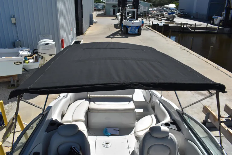 Slide: The Image of 2005 Crownline 275 CCR boat with black canopy and white interior, docked at marina. - 26