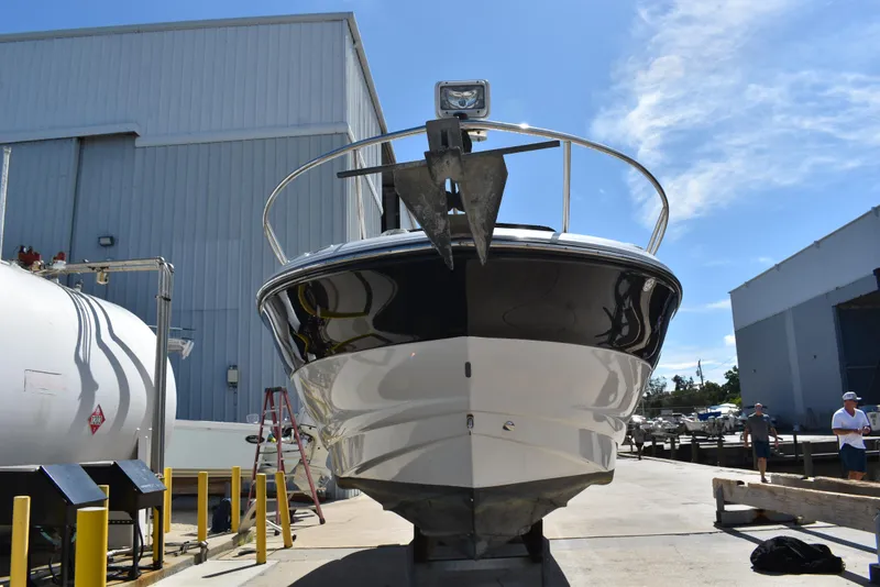 Slide: The Image of 2005 Crownline 275 CCR boat in a marina, front view under clear sky. - 3