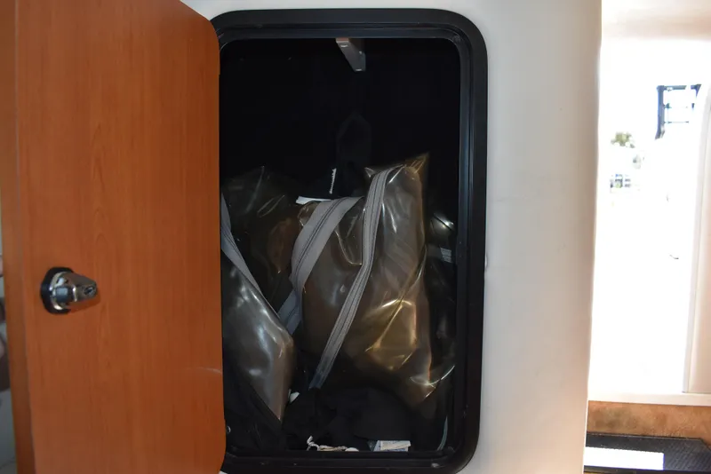 Slide: The Image of Storage compartment on a 2005 Crownline 275 CCR boat with bags inside. - 34