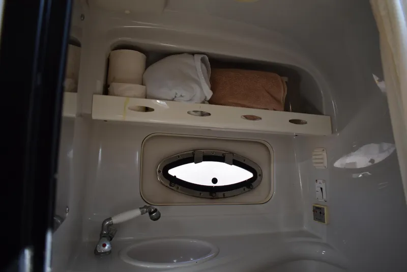 Slide: The Image of 2005 Crownline 275 CCR boat bathroom with shelf, towels, and porthole window. - 35