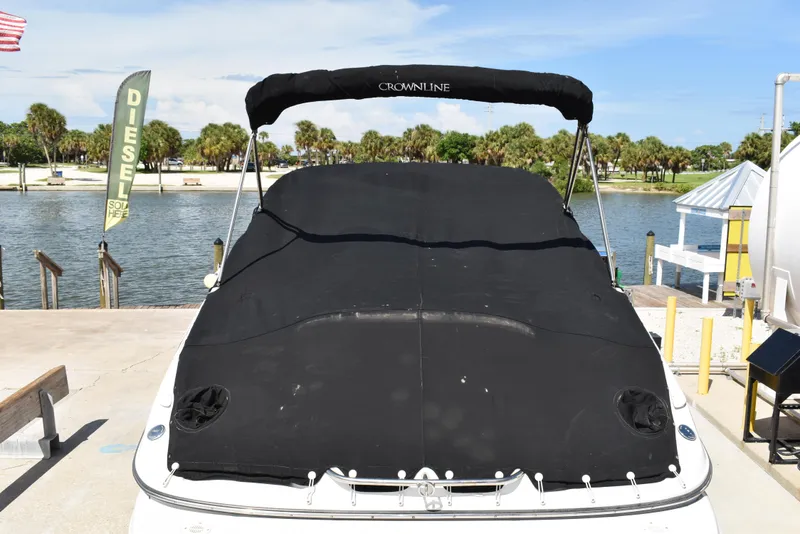 Slide: The Image of 2005 Crownline 275 CCR boat with black cover docked by a scenic lake. - 48