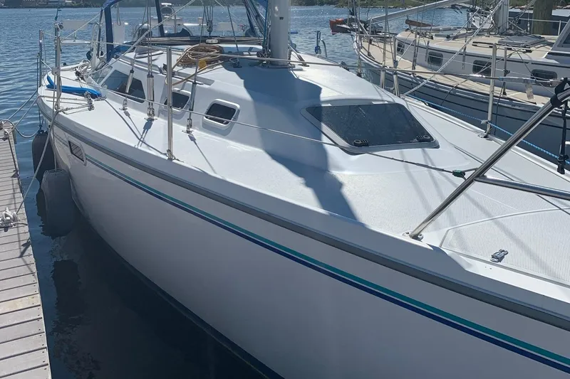 Slide: The Image of 1998 Catalina 320 sailboat docked at a marina, featuring sleek white design. - 10