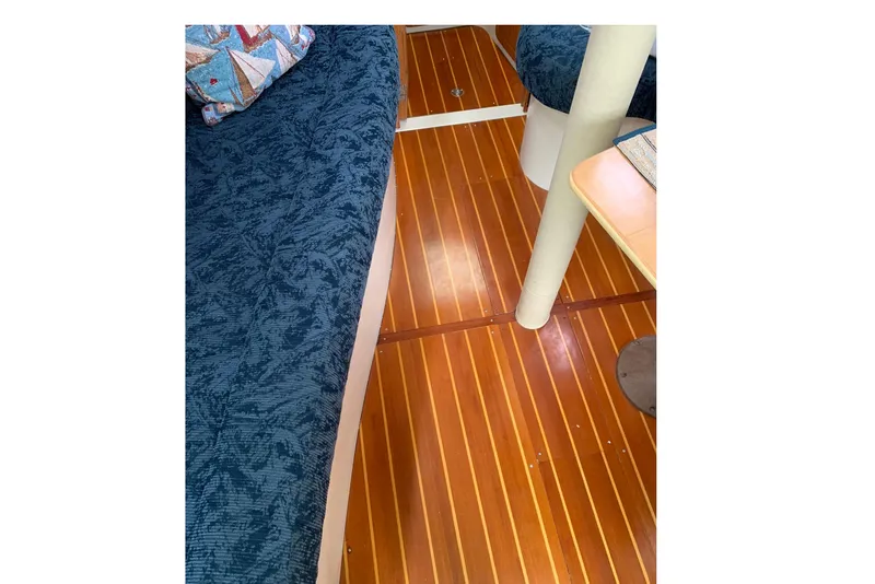 Slide: The Image of Interior of 1998 Catalina 320 sailboat with wooden flooring and blue upholstery. - 11