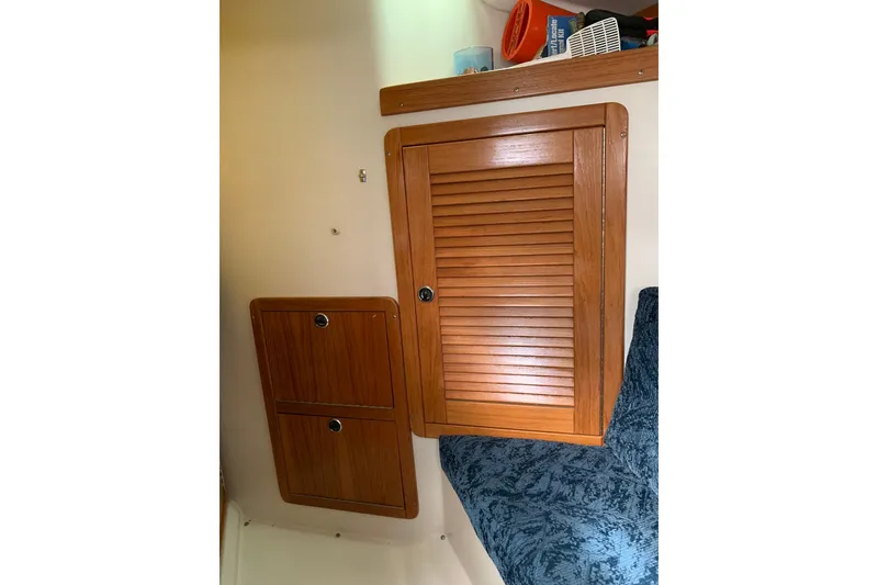 Slide: The Image of Interior of 1998 Catalina 320 sailboat with wooden cabinets and blue upholstery. - 12