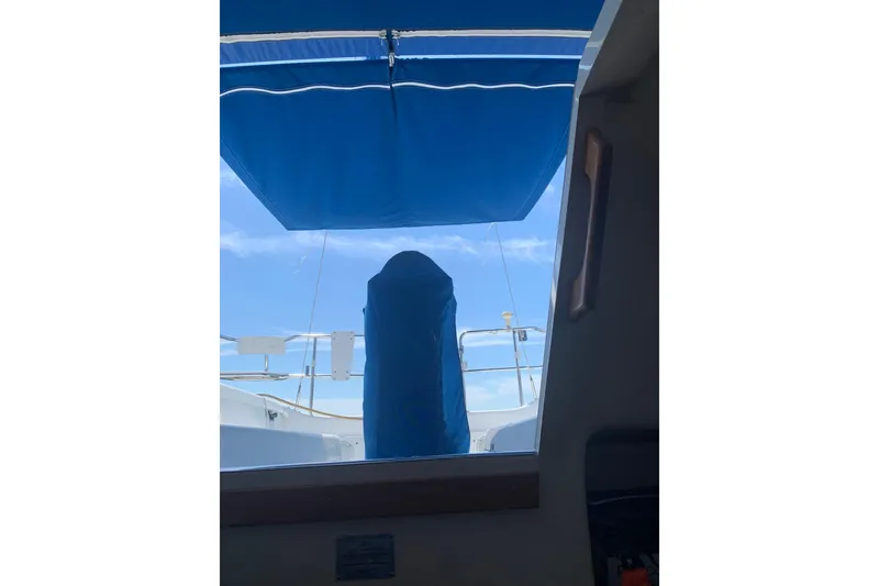 Slide: The Image of View from inside a 1998 Catalina 320 sailboat, featuring a blue canopy and clear sky. - 14