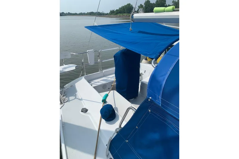 Slide: The Image of 1998 Catalina 320 sailboat with blue canopy on calm water. - 15