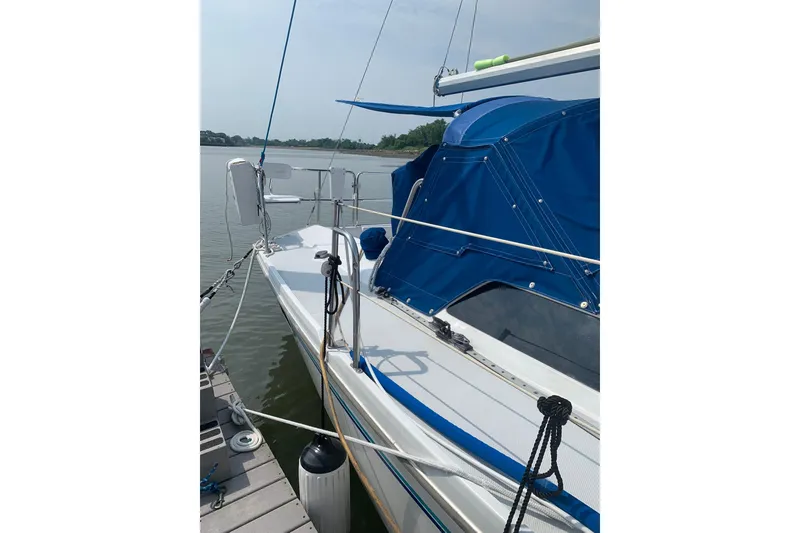 Slide: The Image of 1998 Catalina 320 sailboat docked, featuring blue canopy and sleek design. - 16