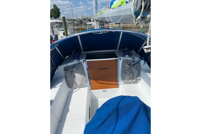Slide: The Image of 1998 Catalina 320 sailboat cockpit with blue canopy and storage compartments. - 17