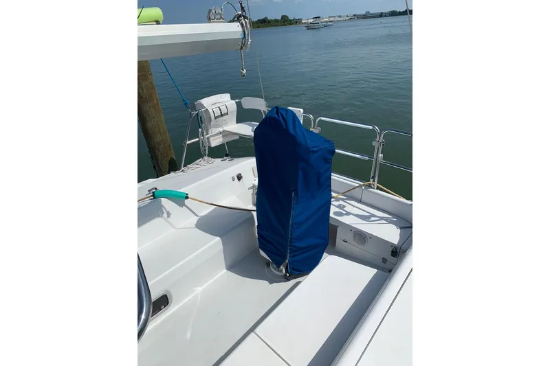 Slide: The Image of 1998 Catalina 320 sailboat deck with blue-covered equipment, docked by calm waters. - 18