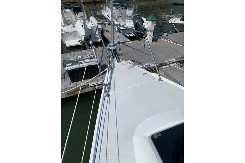 Slide: The Image of 1998 Catalina 320 sailboat deck view at marina, showcasing rigging and docked boats. - 19