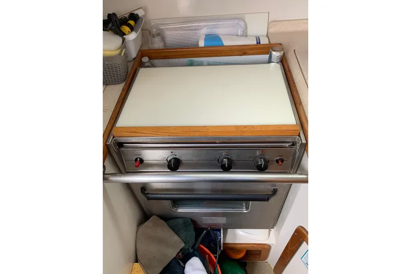 Slide: The Image of Stove in 1998 Catalina 320 yacht kitchen with wooden trim and storage below. - 24