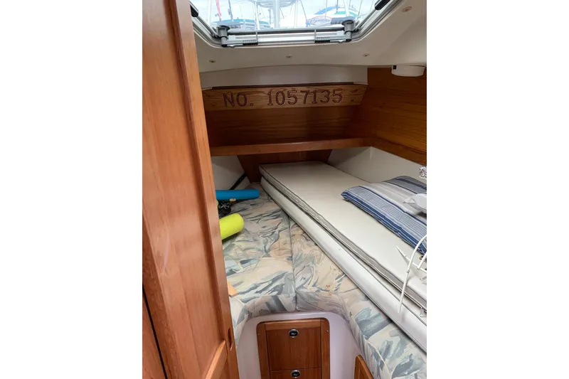 Slide: The Image of 1998 Catalina 320 sailboat cabin interior with bedding and storage. - 29