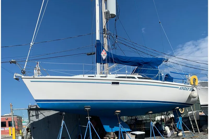 Slide: The Image of 1998 Catalina 320 sailboat on stands, blue sky background, marina setting. - 3