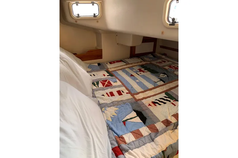 Slide: The Image of Cozy cabin bed in 1998 Catalina 320 sailboat with nautical-themed quilt. - 31