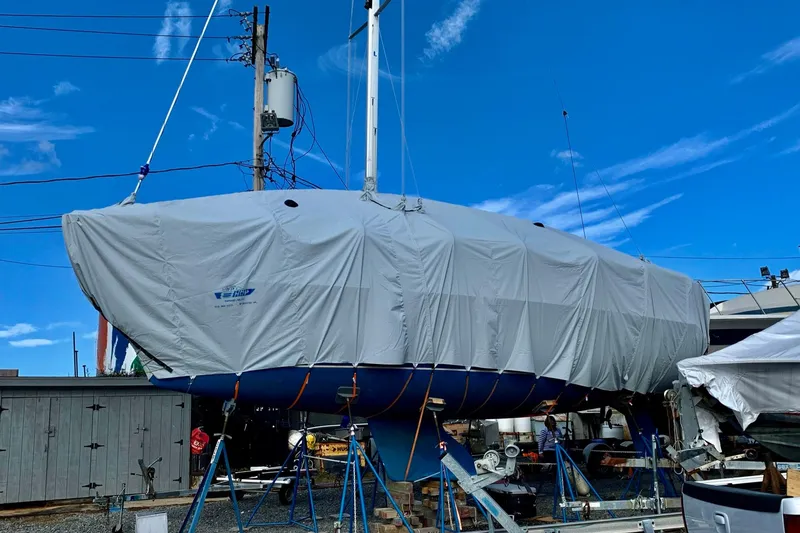Slide: The Image of 1998 Catalina 320 sailboat covered and elevated on stands in a boatyard. - 34