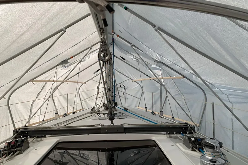 Slide: The Image of 1998 Catalina 320 sailboat under protective cover, showcasing rigging and deck details. - 35
