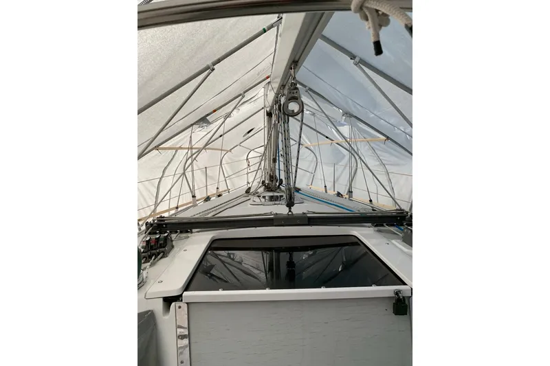 Slide: The Image of 1998 Catalina 320 sailboat under protective cover, showcasing deck and rigging. - 36
