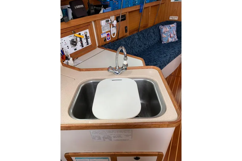 Slide: The Image of Interior of 1998 Catalina 320 sailboat featuring a compact kitchen sink and cozy seating area. - 4