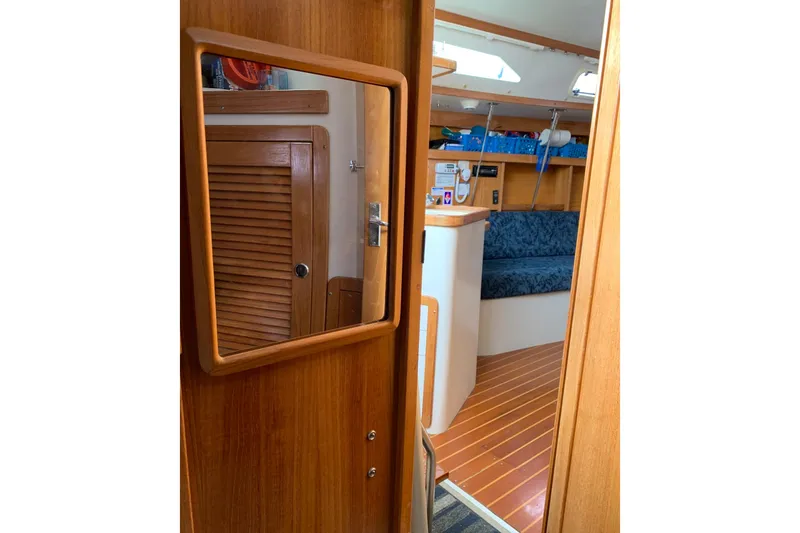 Slide: The Image of Interior of 1998 Catalina 320 sailboat with wooden finishes and blue seating. - 5