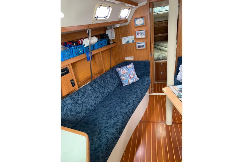 Slide: The Image of Interior of 1998 Catalina 320 sailboat with blue seating and wooden accents. - 6
